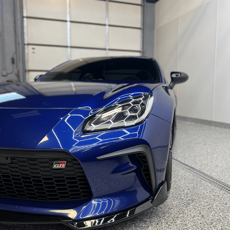 Close-up of a blue Toyota GR86 front end with polished paint and detailed headlight